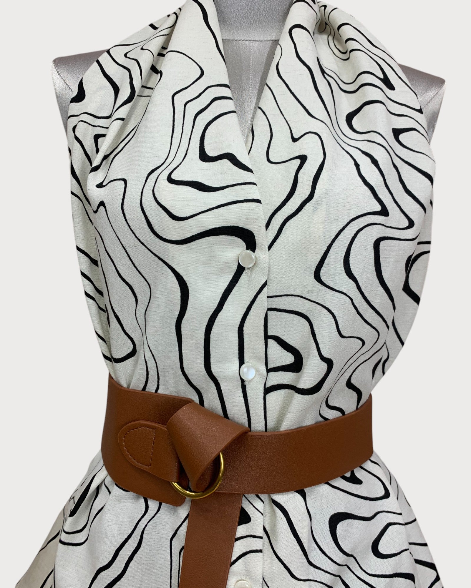 Top peplum estampado sin mangas con cinturón.